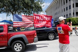 A small caravan of vehicles with Trump flags drove past the court in West Palm Beach, Florida, as the hearing kicked off [Marco Bello/Reuters]