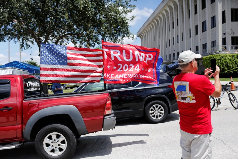 Un camion avec un drapeau américain et un drapeau pro-Trump passe devant un palais de justice de Floride
