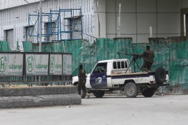 Somali police officers ride on their pick-up truck towards Hotel Hayat.