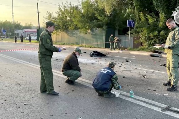 Investigators work at the site of a suspected car bomb attack that killed Darya Dugina near Moscow, Russia.