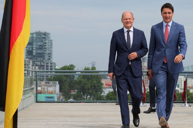 German Chancellor Olaf Scholz walks alongside Canadian Prime Minister Justin Trudeau