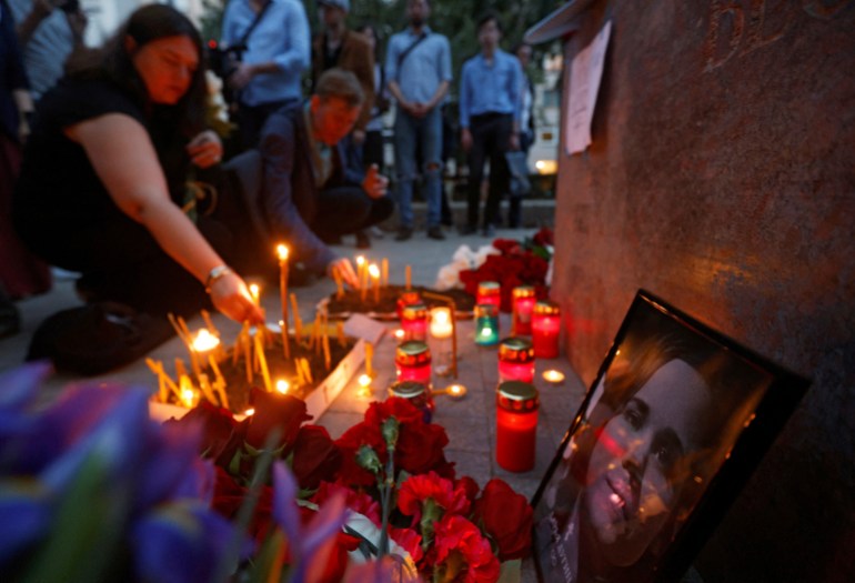 Flowers and candles are placed next to a portrait of media commentator Darya Dugina, who was killed in a car bomb attack, in Moscow, Russia August 22, 2022. REUTERS/Maxim Shemetov