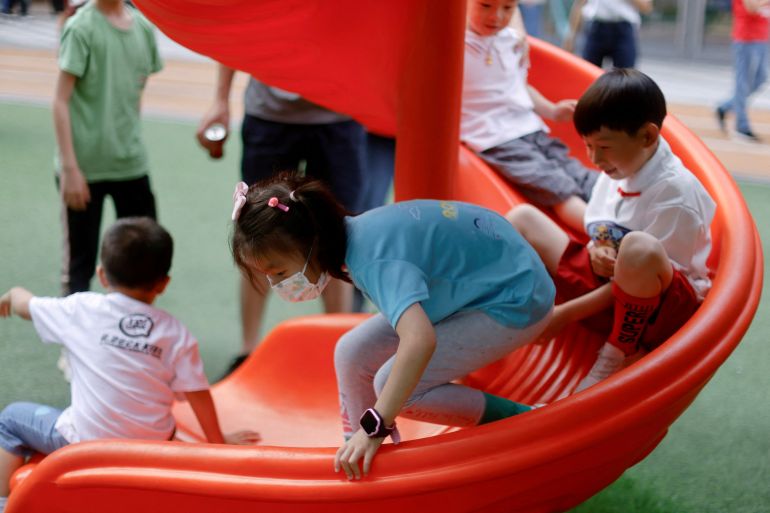 Children going down a slide at a playground inside a shopping complex in Shanghai, China.