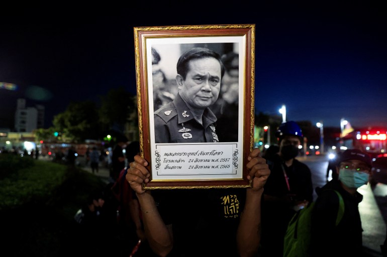 A person holds up a picture of Prime Minister Prayuth Chan-ocha during a protest near Government House