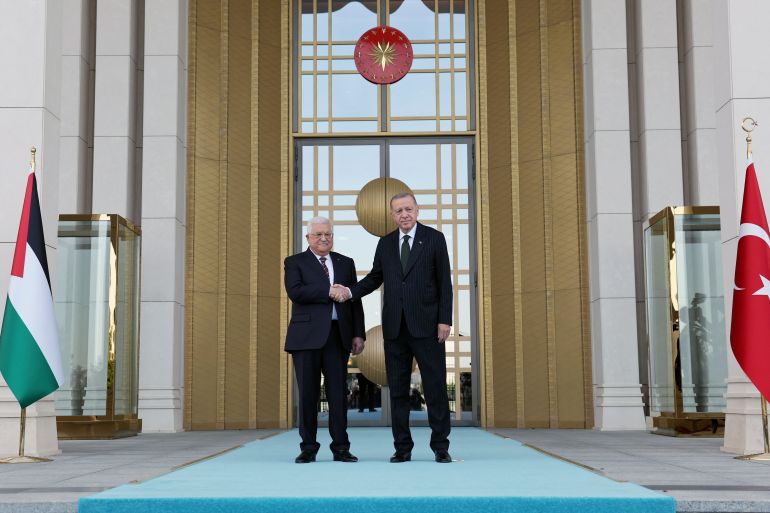 Turkish President Tayyip Erdogan and Palestinian President Mahmoud Abbas shake hands