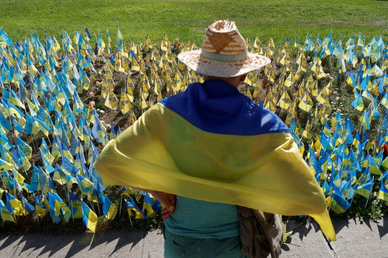 A man stands next to Ukrainian flags at the Independence square in Kyiv