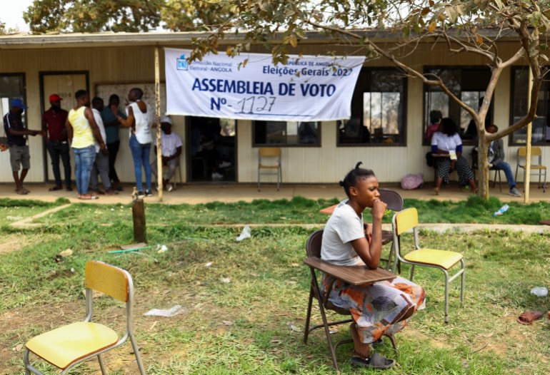 A woman sits outside a voting station after casting her vote 
