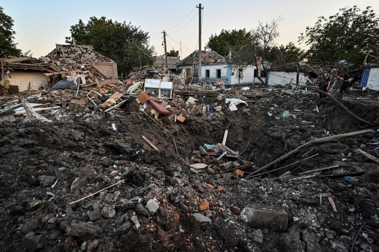 People stand next to a residential house destroyed by a Russian military raid in Chaplyne, Dnipropetrovsk region, Ukraine.
