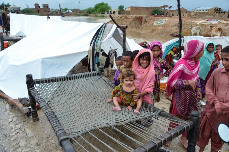 Une famille se réfugie sur un terrain plus élevé après les pluies et les inondations