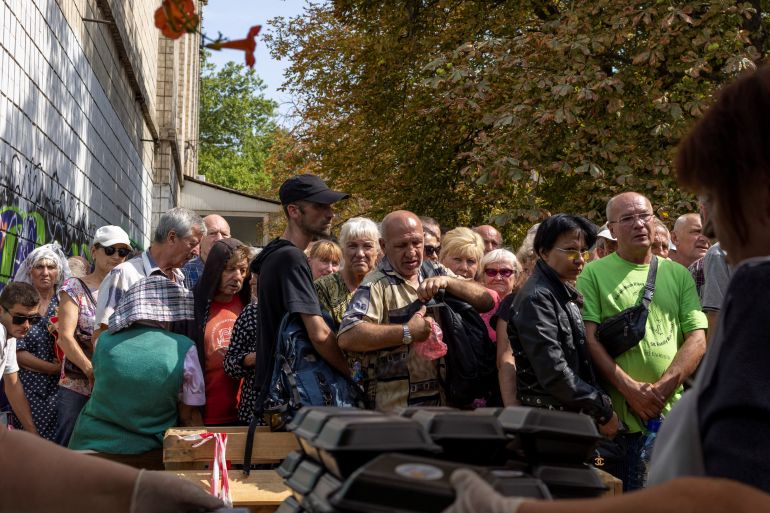 People line up to receive a meal in Mykolaiv.