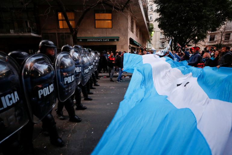 Supporters gather outside the house of Argentina's Vice President Cristina Fernandez de Kirchner as police officers hold their shields, days after Fernandez was accused in a corruption case, in Buenos Aires.