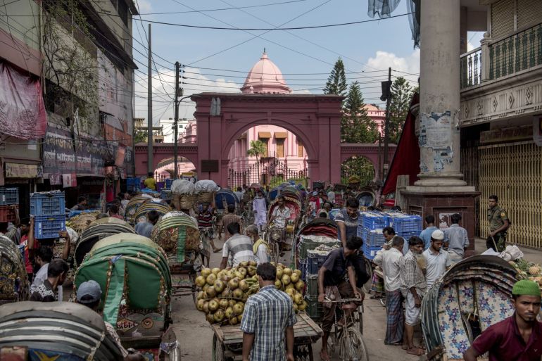 Rickshaw pullers and market vendors gather outside the Ahsan Manzil, the former official residential palace and seat of the Nawab of Dhaka, in Dhaka, Bangladesh