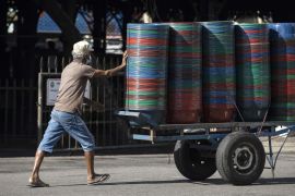 A worker pushes a cart carrying plastic containers in Colombo, Sri Lanka.