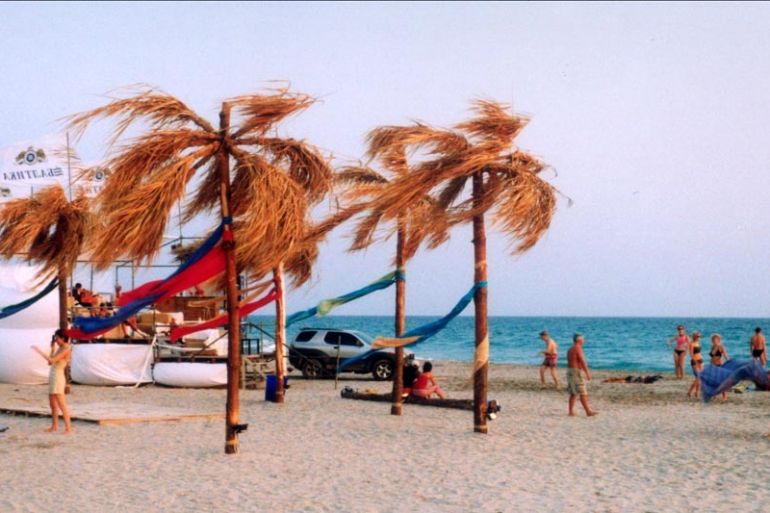 A photo of a beach with people sunbathing and walking around during the KaZantip festival.