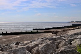Landscape view of groynes and rock armour on the beach of Eastchurch, on the Isle of Sheppey.