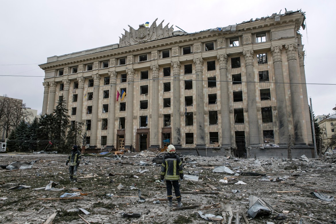 A member of the Ukrainian Emergency Service looks at the City Hall building in the central square following shelling in Kharkiv, Ukraine