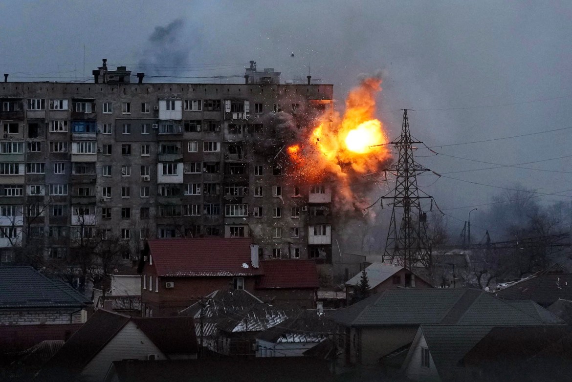 An explosion is seen in an apartment building after Russian's army tank fires in Mariupol, Ukraine
