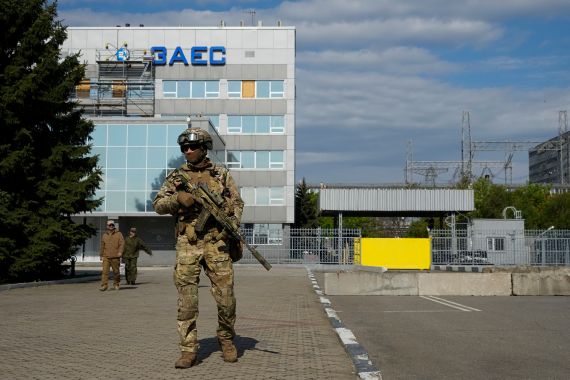 A Russian service member stands guard near the Zaporizhzhia Nuclear Power Station in territory under Russian military control, southeastern Ukraine