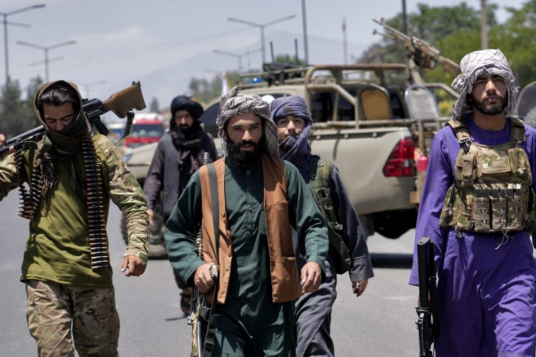 Taliban fighters guard at the site of an explosion in Kabul.