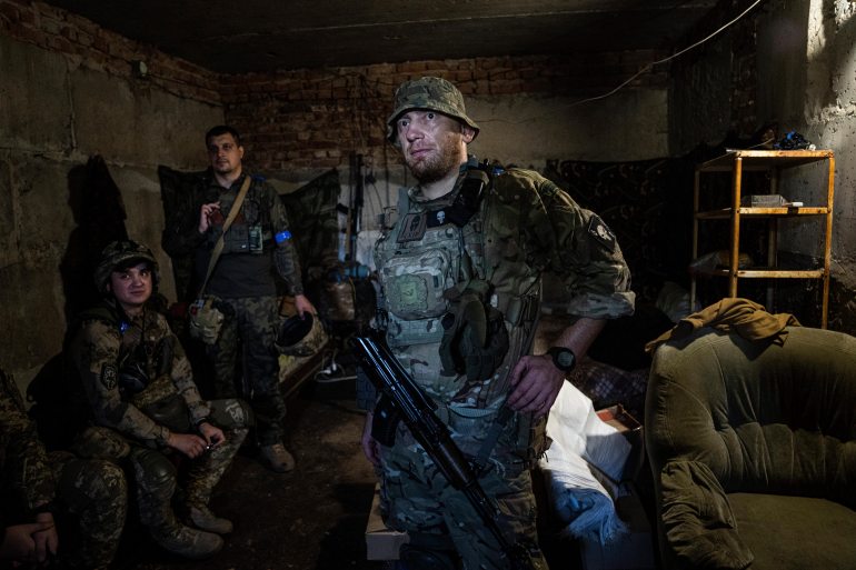 Ukrainian servicemen wait for the end of shelling in a basement at the frontline in Kharkiv region, Ukraine, Saturday, July 23, 2022.