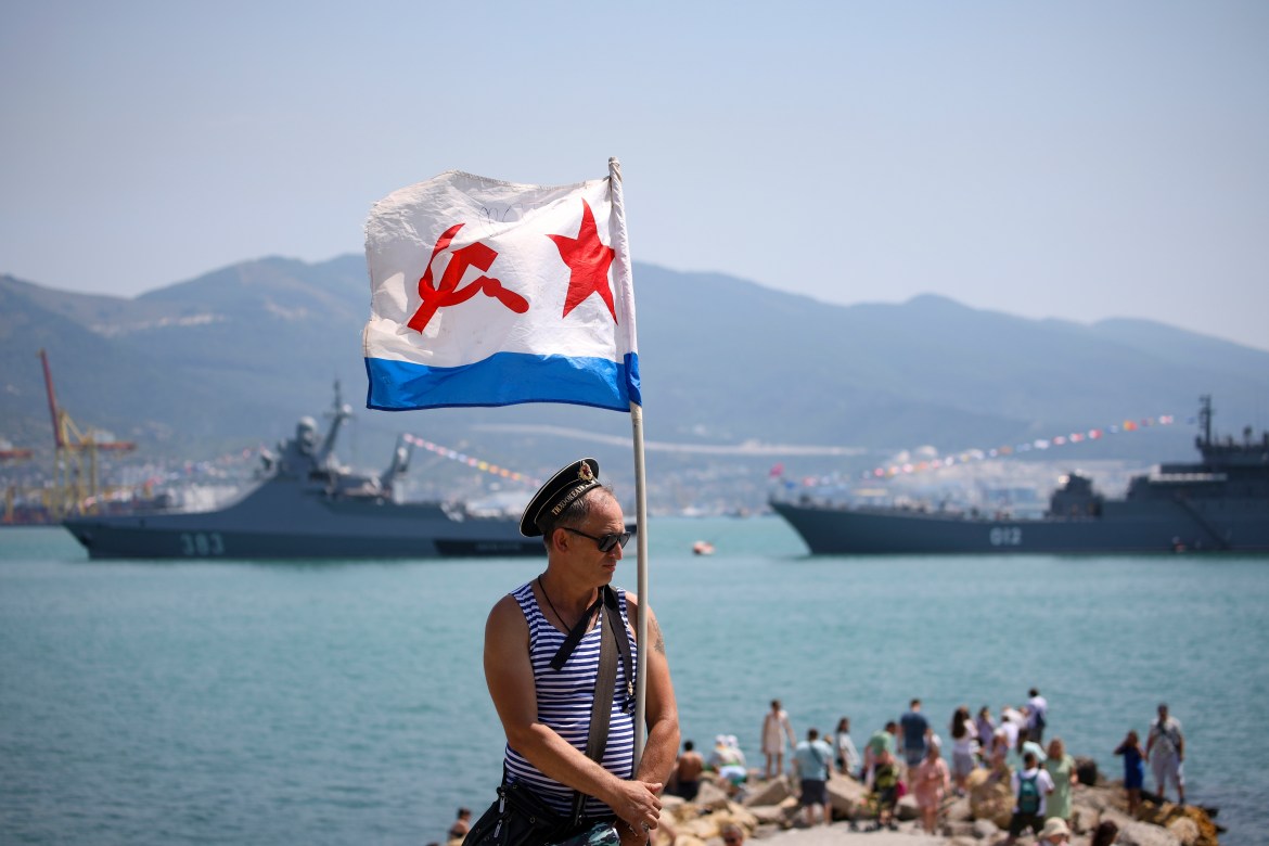 A man holds a Soviet era Navy flag during the Navy Day celebration