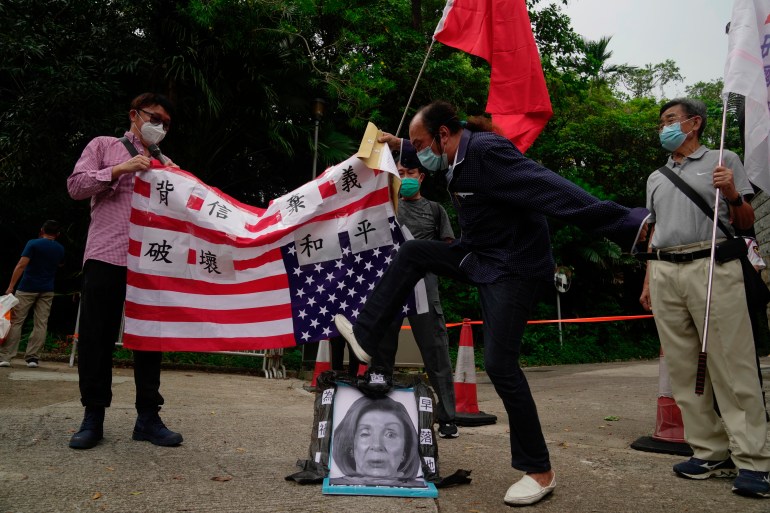 친중국 지지자들이 2022년 8월 3일 홍콩 주재 미국 총영사관 앞에서 항의하는 동안 낸시 펠로시 미국 하원 의장의 사진을 밟고 있다. [Kin Cheung/AP]