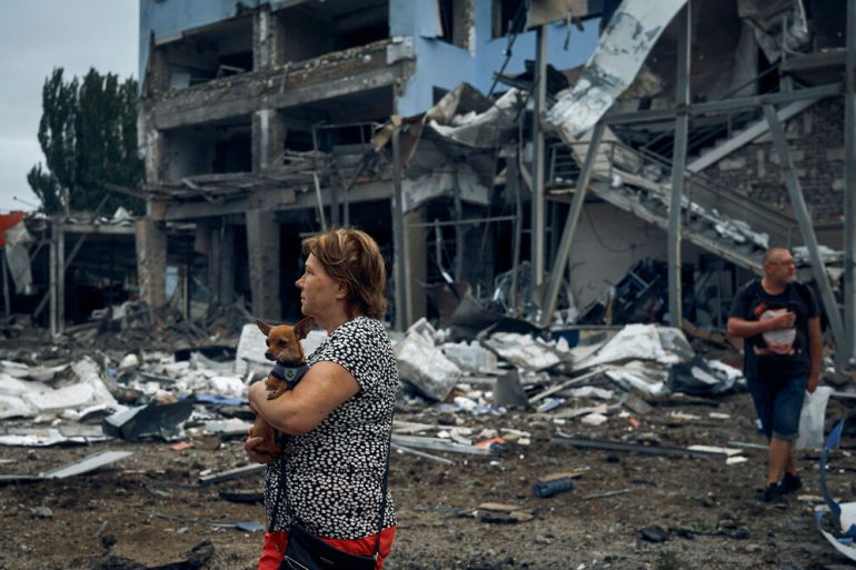 Woman in front of destroyed building