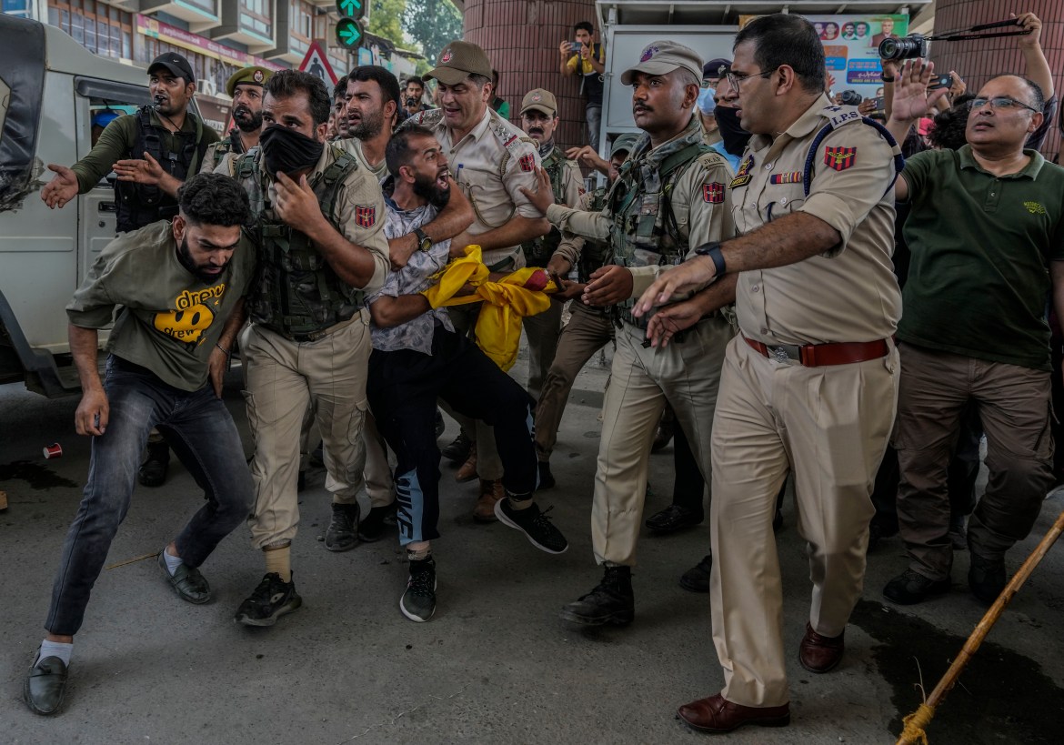Indian policemen detain Kashmiri