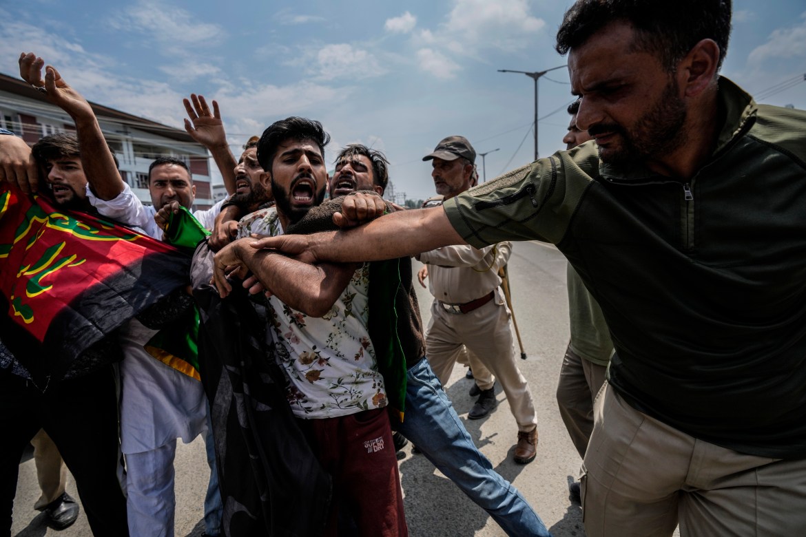 Indian policemen detain Kashmiri