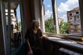 Ida Svystunova, 89, looks out of her damaged room adjoining her apartment from a May rocket attack in Sloviansk, Donetsk region, eastern Ukraine