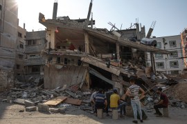 Palestinians inspect their house