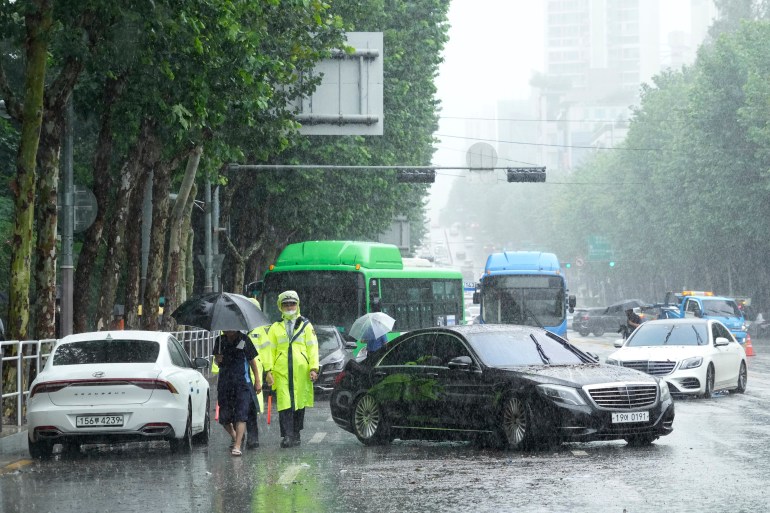 Vehicles, which had been submerged by the heavy rainfall, block a road in Seoul, South Korea.