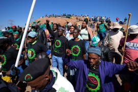 Mine workers sing as they wait for the start of commemoration ceremonies near Marikana in Rustenburg, South Africa [Themba Hadebe/AP Photo]