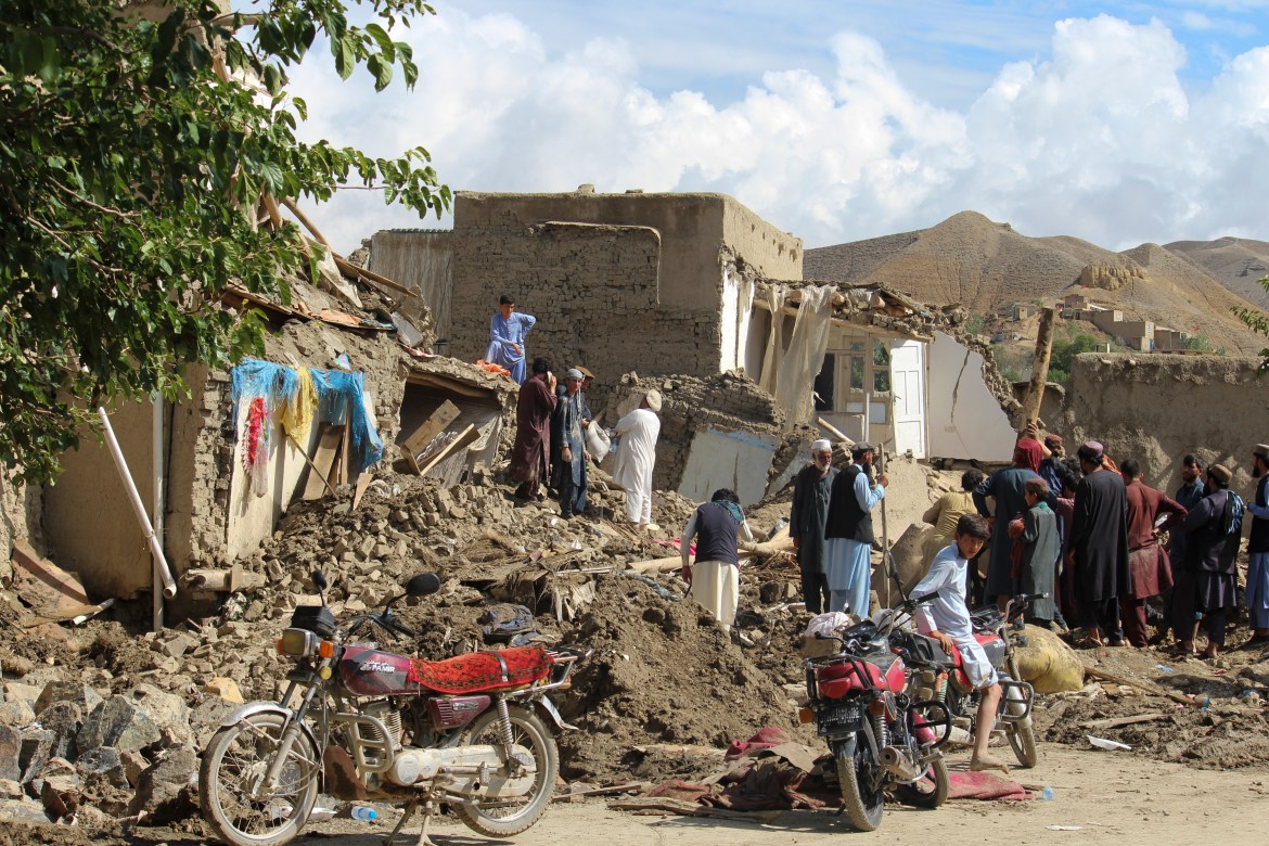 People clean up their damaged homes after heavy flooding in the Khushi district of Logar province south of Kabul, Afghanistan.