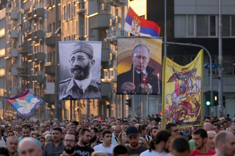 People display the images of Russian President Vladimir Putin, center, and controversial Serb World War II leader Gen. Dragoljub Draza Mihailovic, left, during a protest against the international LGBT event EuroPride in Belgrade