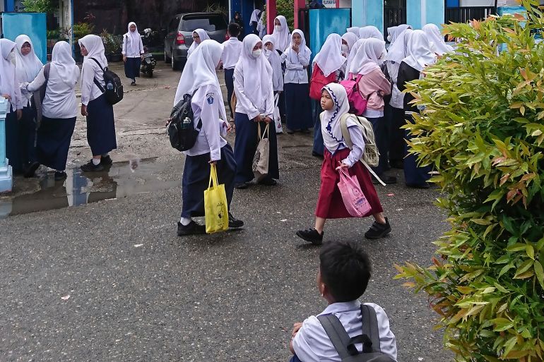 Students wait outside their school as classes are dismissed early following an earthquake in Padang, West Sumatra, Indonesia, August 29, 2022