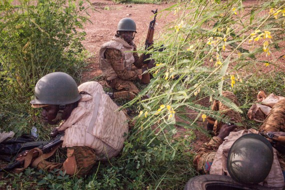 Burkina Faso government soldiers take cover as they patrol a suburb
