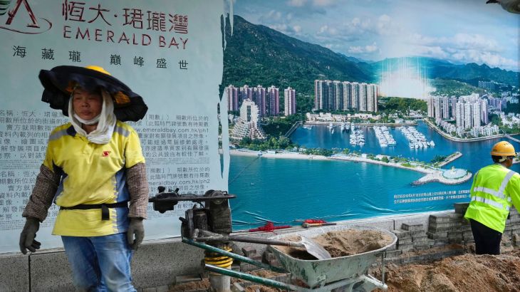 A worker walks past an Huge photo of a property project