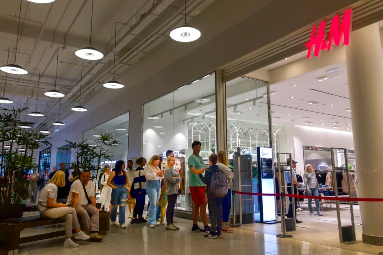 People line up to enter an H&amp;M shop and buy items on sale in the Aviapark shopping mall in Moscow, Russia