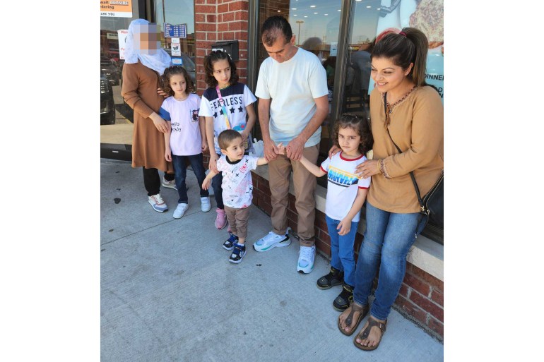 A photo of Mina standing with Abdul, his wife, and four children outside a kebab shop in Toronto