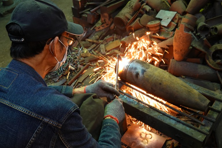 Wu works on an old seashell with a cutting torch