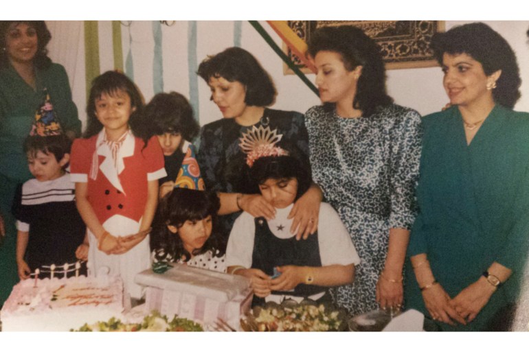 A photo showing a birthday celebration from the 1980s with mothers, aunties, and children