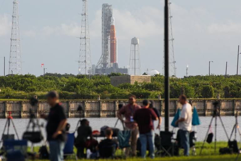 News media members react as NASA's next-generation moon rocket, the Space Launch System (SLS) , with its Orion crew capsule on top, sits on the pad after the launch of the Artemis I mission was scrubbed, at Cape Canaveral, Florida, U.S.,