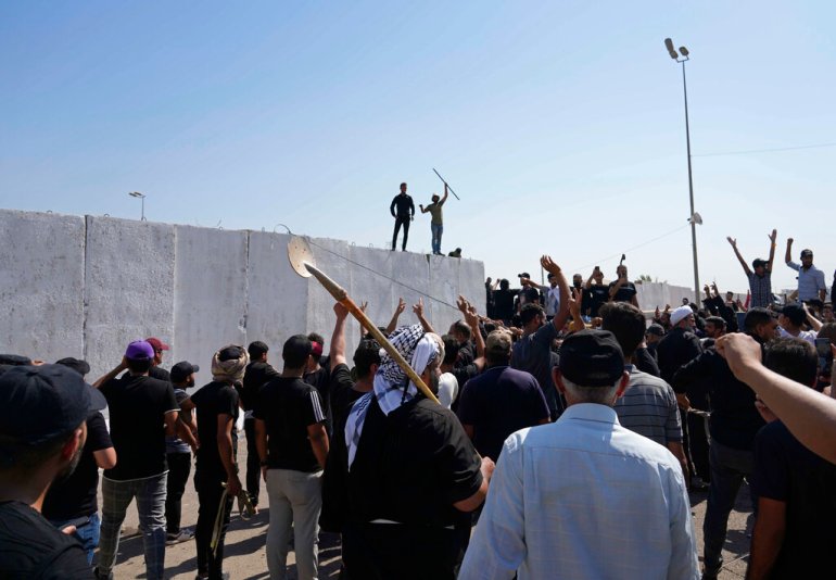 Iraq protests: Supporters of Muqtada al-Sadr try to remove concrete barriers in the Green Zone area of Baghdad