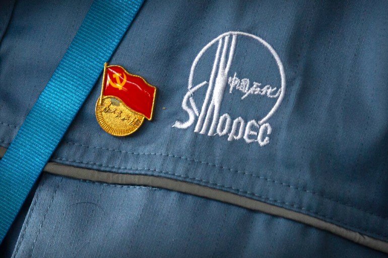 A Chinese Communist Party badge is pinned to a worker's uniform at the Sinopec Yanshan Petrochemical Company on the outskirts of Beijing