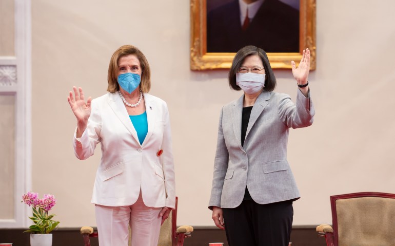 Taiwan President Tsai Ing-wen and US House Speaker Nancy Pelosi wave to cameras during a photo-op.