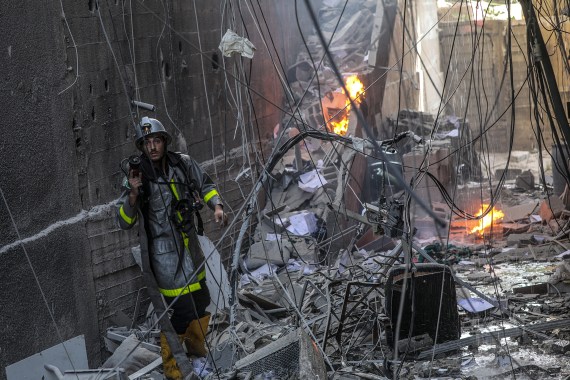 epa10107275 A Palestinian fireman works at the site of a destroyed building