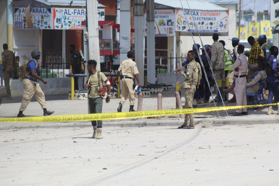 Somali security officials gather at the cordoned-off scene of an attack, outside the Hayat Hotel in Mogadishu, Somalia.