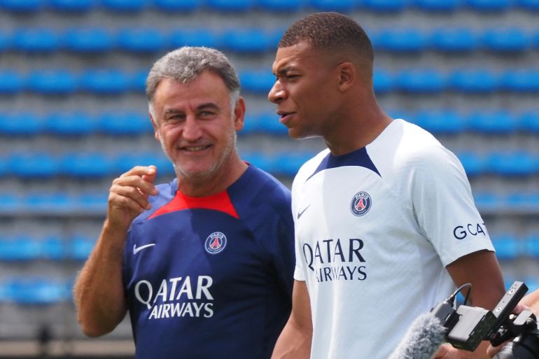 France's football team Paris Saint-Germain player Kylian Mbappe (R) chats with head coach Christophe Galtier while attending a soccer clinic at a stadium in Tokyo on July 18, 2022, as a part of the teams pre-season summer tour of Japan. (Photo by TOSHIFUMI KITAMURA and Toshifumi KITAMURA / AFP)