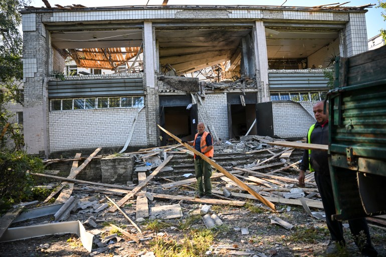 Workers collect debris from a psychiatric hospital 